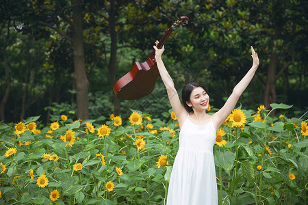 向日葵中拿着吉他的少女背景