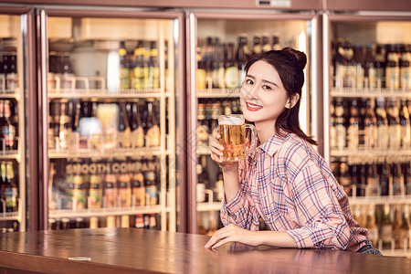 年轻美女酒吧喝啤酒高清图片
