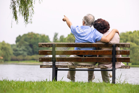 老人坐老年夫妇坐公园椅子背影背景