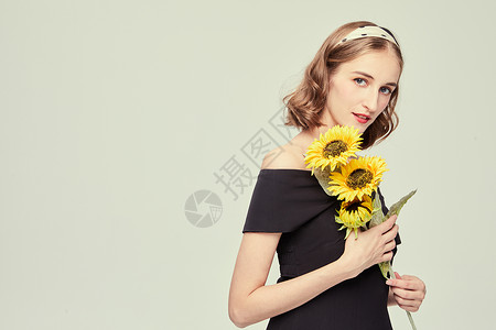 优雅女性拿着向日葵背景图片