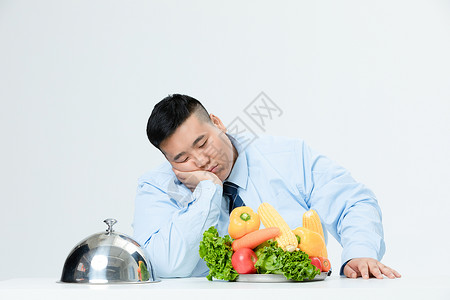 肥胖商务男性吃蔬菜厌烦背景