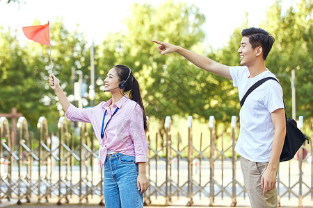 女导游给游客介绍景点背景图片