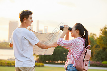 年轻情侣拿着地图旅行背景图片