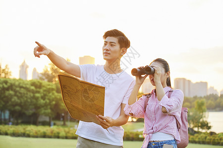年轻情侣拿着地图旅行背景图片