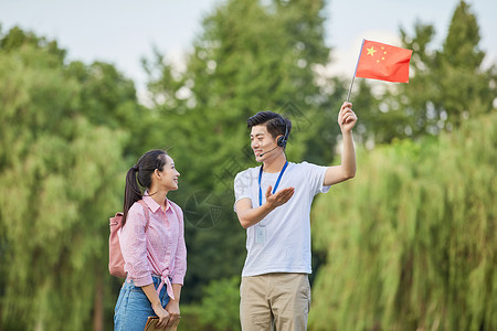 巨型旗子男性导游给游客做介绍背景