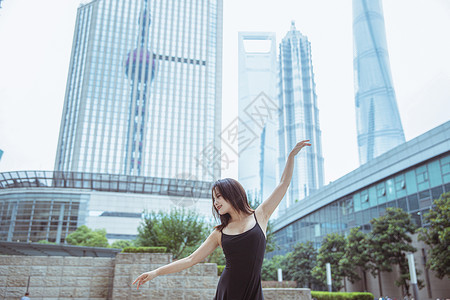在城市建筑下舞蹈的女性图片
