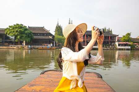 年轻美女乘船郊游拍照高清图片