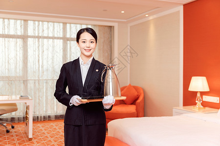 酒店服务贴管拿着托盘热水瓶背景图片