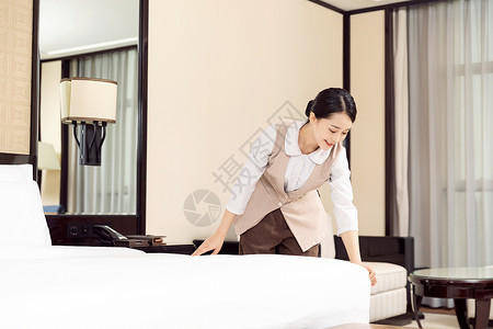 酒店管理保洁员整理床铺背景图片
