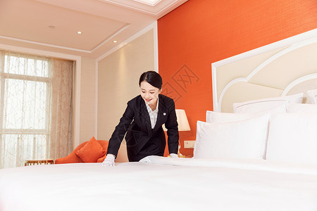 酒店服务贴身管家整理床铺背景图片