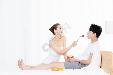 亲密情侣躺在床上吃水果图片
