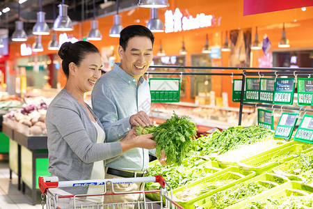 超市大促中年夫妇超市选购蔬菜背景
