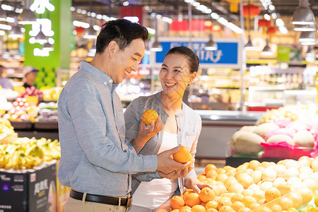 超市购物人物中年夫妻超市挑选水果背景