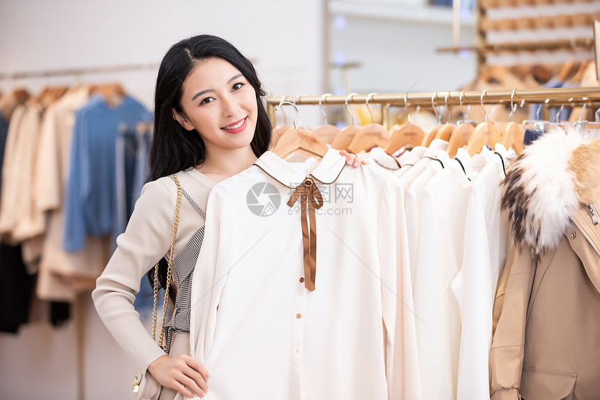 年轻美女商场购物挑选衣服图片