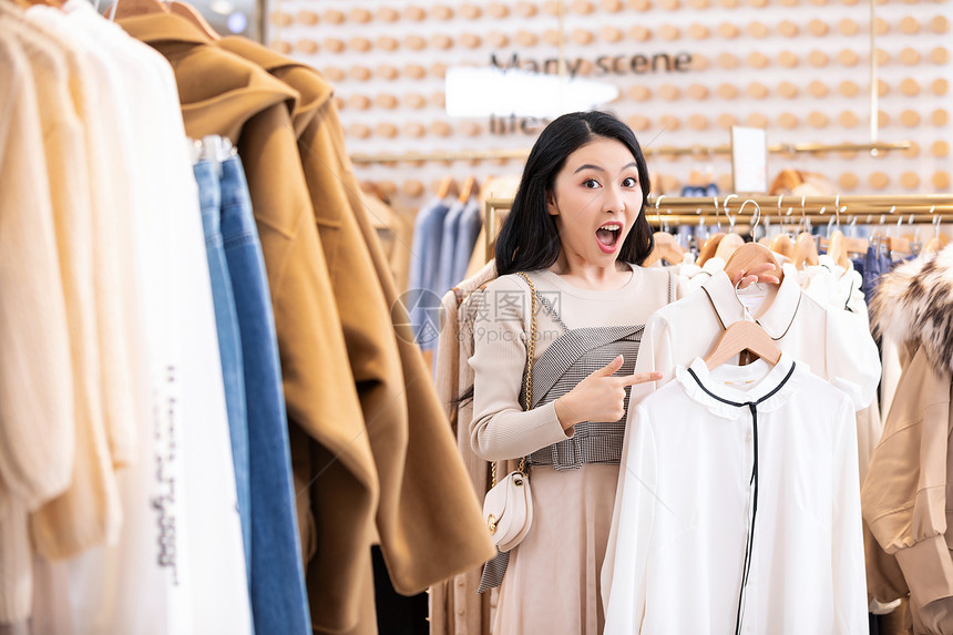 年轻美女商场购物挑选衣服图片