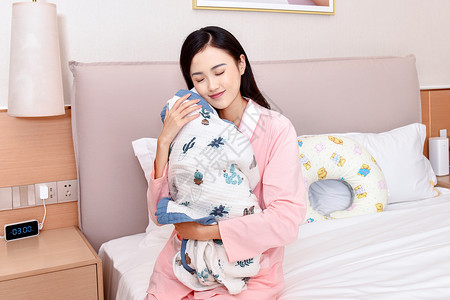 宝宝加绒睡衣母亲闭眼抱着新生婴儿背景