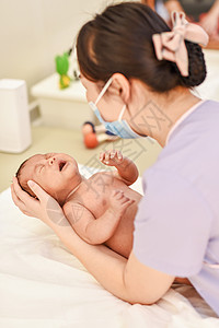 宝宝戴口罩护士给新生儿按摩背景