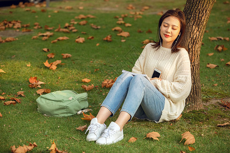 戴耳机看书人甜美女生户外听音乐背景