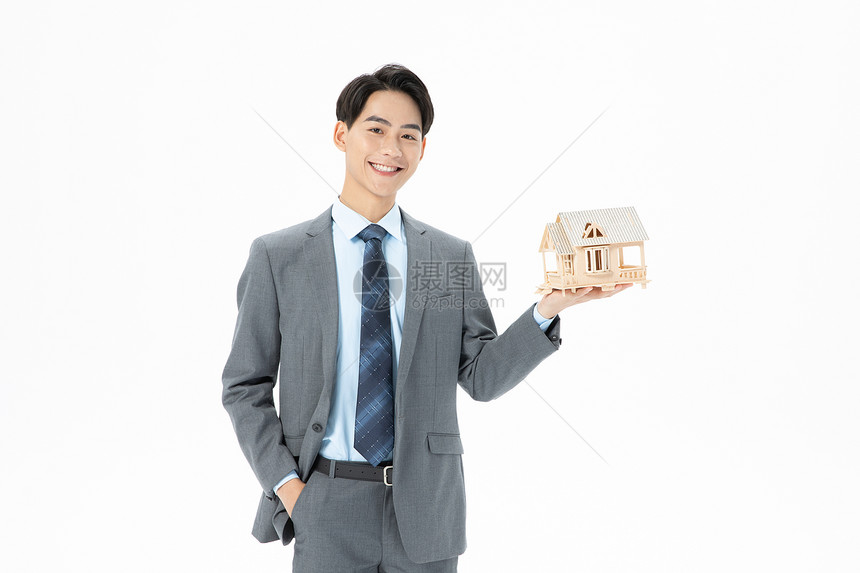 青年商务男性抱着房子模型图片
