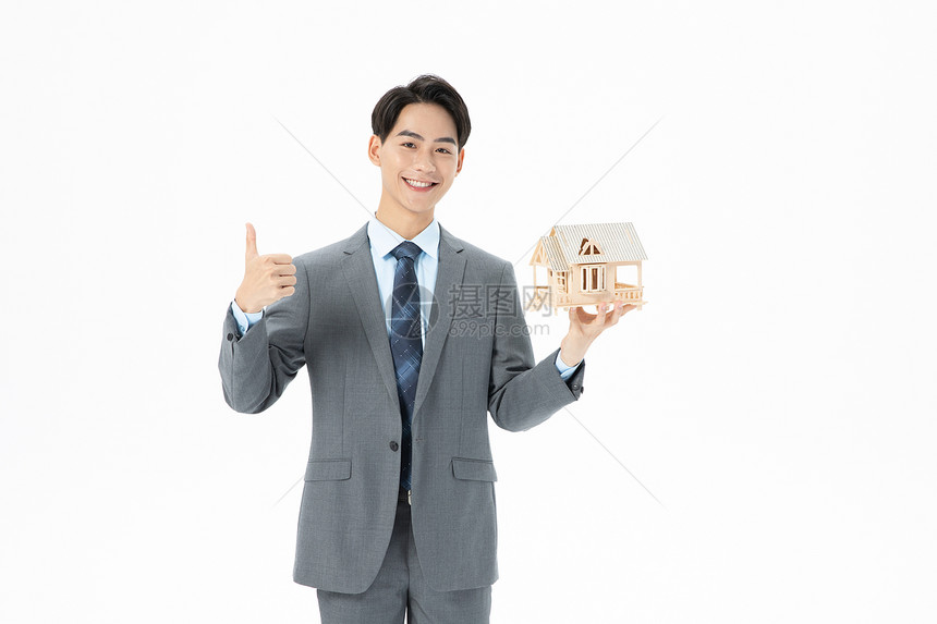 青年商务男性抱着房子模型图片
