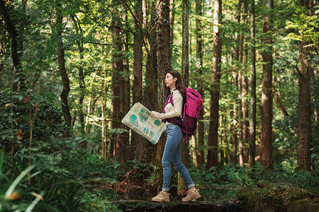运动路线青年女性森林里看地图背景