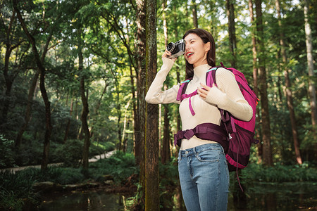 青年女性在森林里拍照高清图片