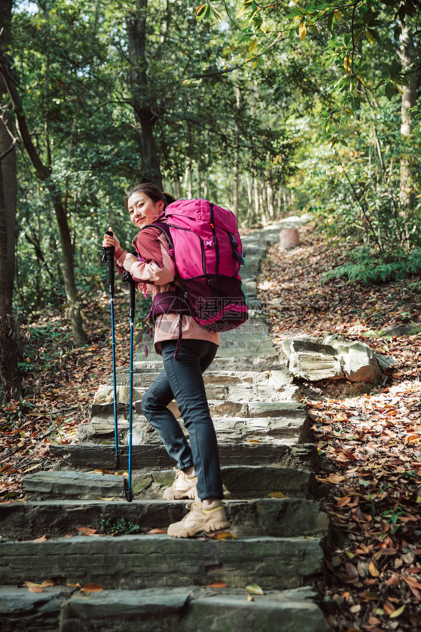 用登山杖爬山的女性形象图片