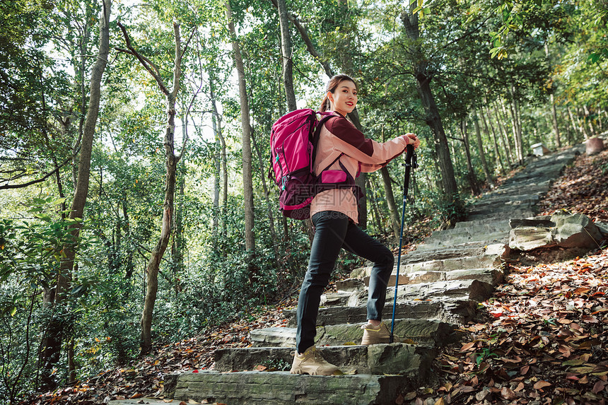 用登山杖爬山的女性形象图片