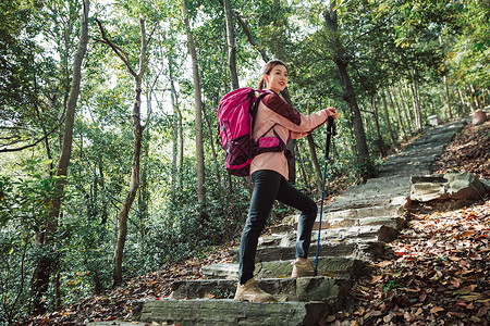 用登山杖爬山的女性形象图片