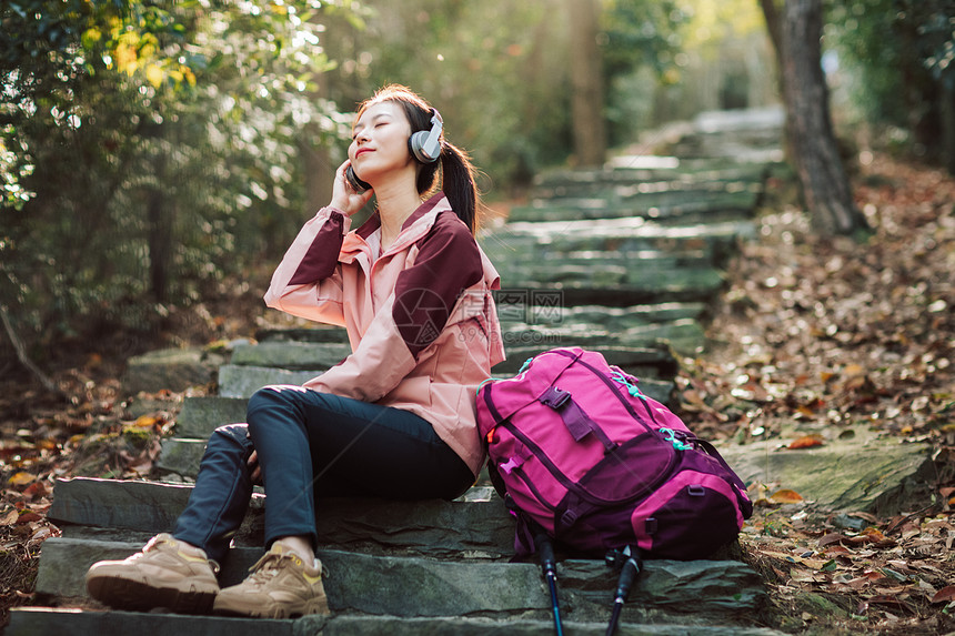 女生坐在山间小路上听音乐图片