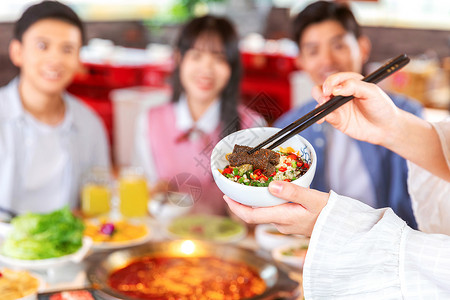 青年聚会吃火锅蘸酱高清图片