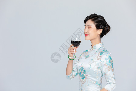 旗袍女性拿红酒背景图片
