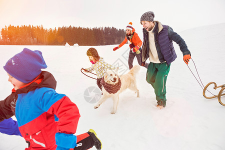 一家人和狗在雪地里奔跑高清图片