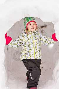穿着冬衣站在雪屋里的女孩背景图片