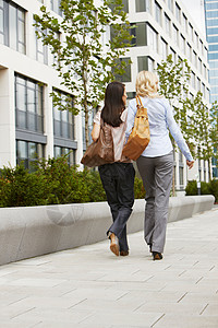 两位外国商务女性走在人行道上图片