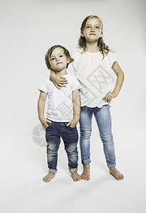 摄影棚的自信女孩的画像，手臂搂着她哥哥图片
