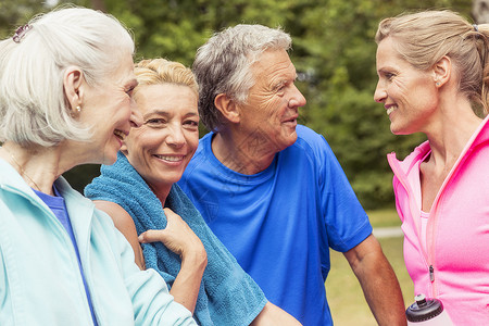 健身了解一下一组成年人在运动户外微笑中休息背景