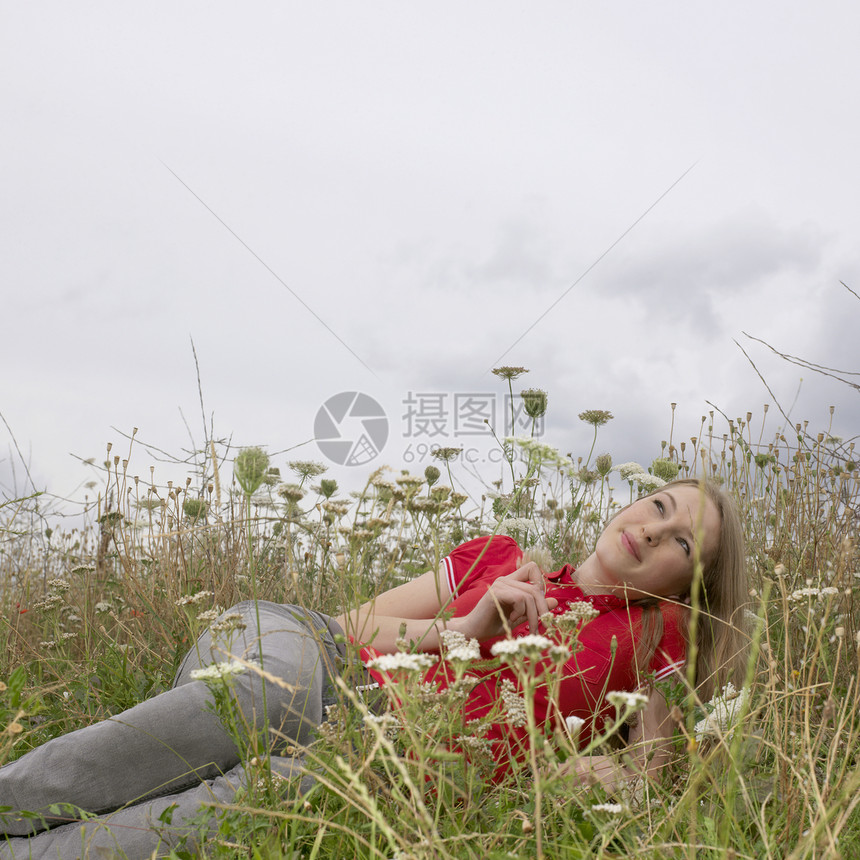 年轻的女人躺在草丛中图片