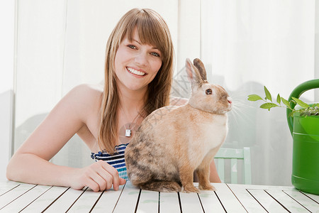年轻的女人和一只宠物兔子图片
