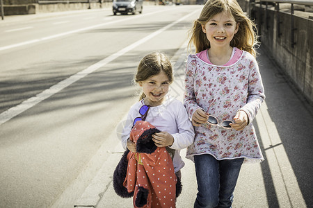 两个年轻女孩一起微笑走在街上图片