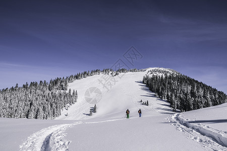 滑雪图素材两名男性滑雪者在德国斯皮津西冰雪覆盖的山上行走的远视图背景