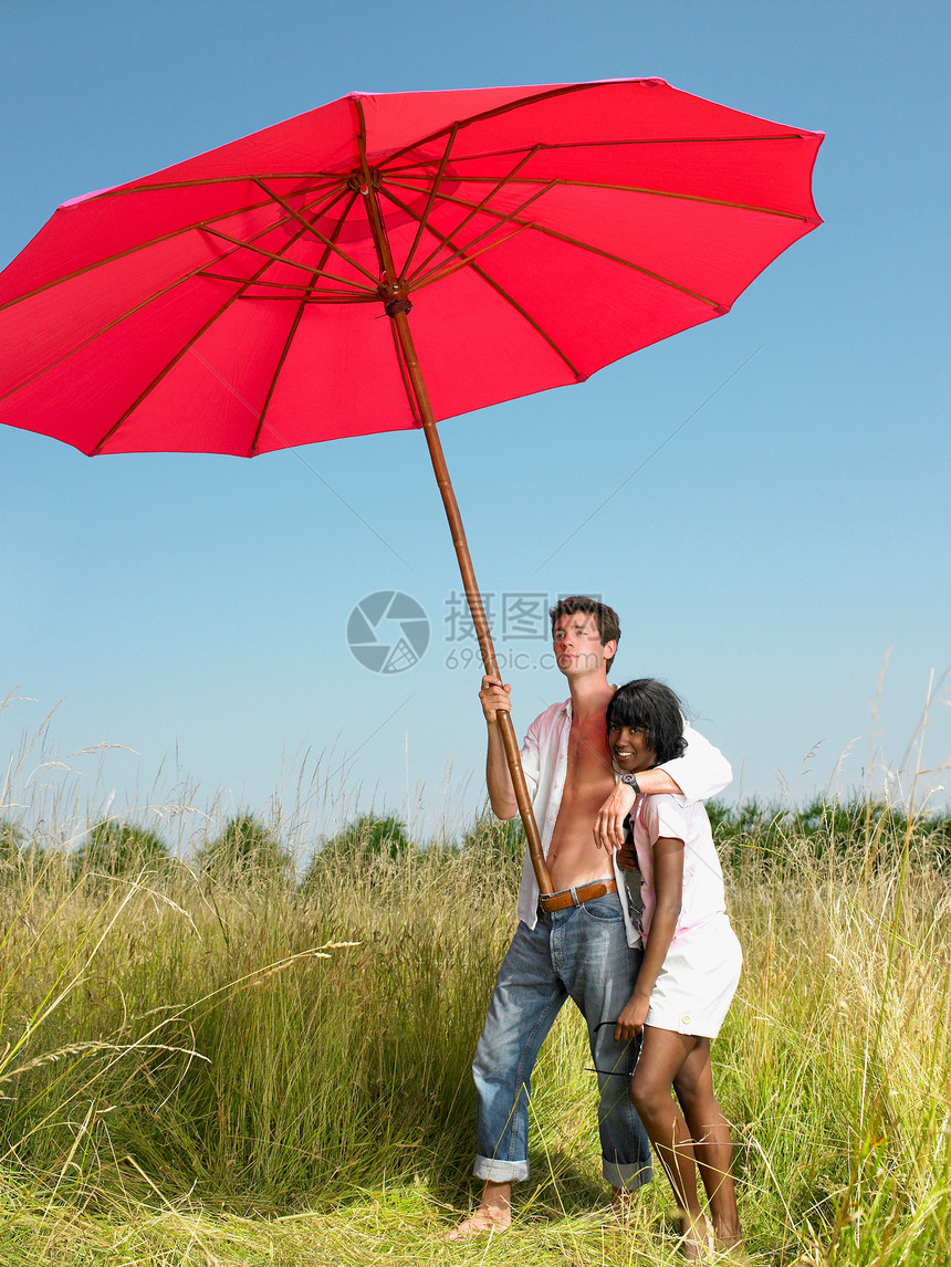 在田里带着遮阳伞的情侣图片