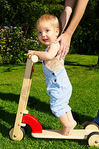 滑车和铲在花园里骑滑滑车的小男孩背景
