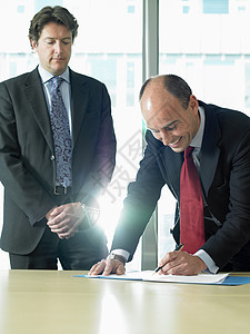 业务人员与合作伙伴签署文件同事高清图片素材