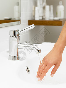 浴室用水水龙头下的女人的手背景
