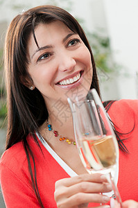 微笑的女人喝着一杯酒图片