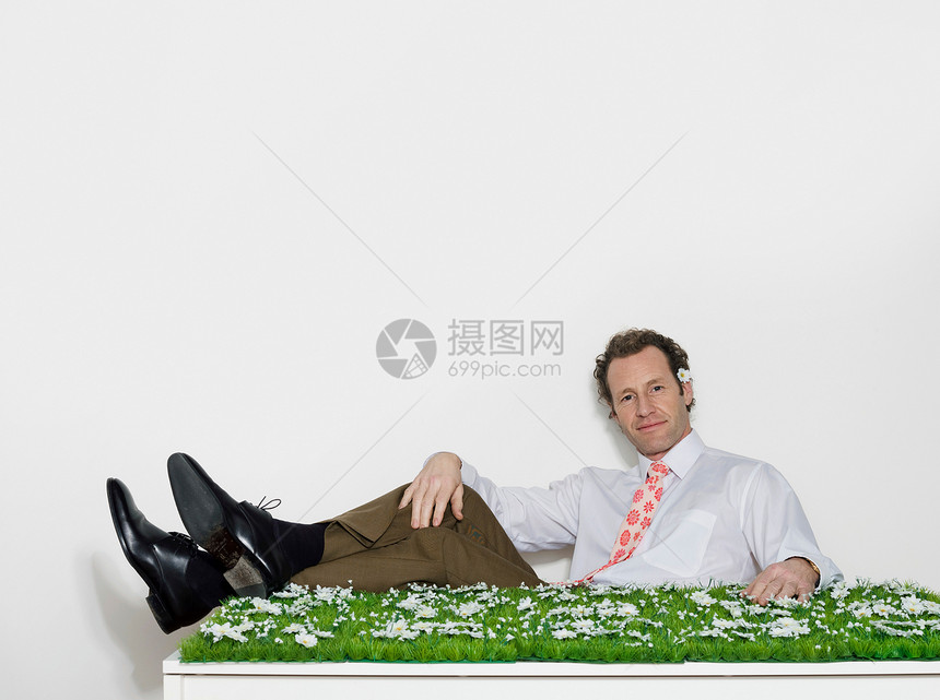 坐在长满草的桌子旁的男人图片