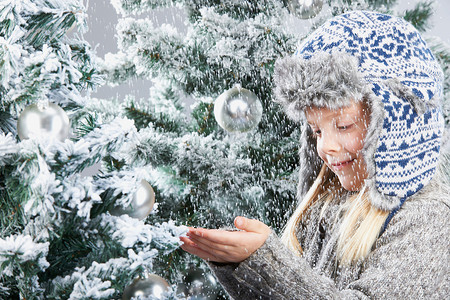 白天的圣诞树雪下的女孩，在圣诞树旁背景