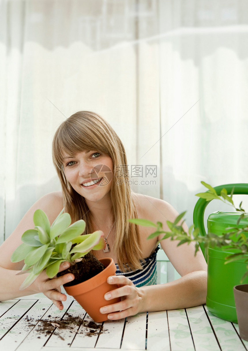 年轻女子和露台上的植物图片