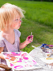 小女孩在绿地上画画图片